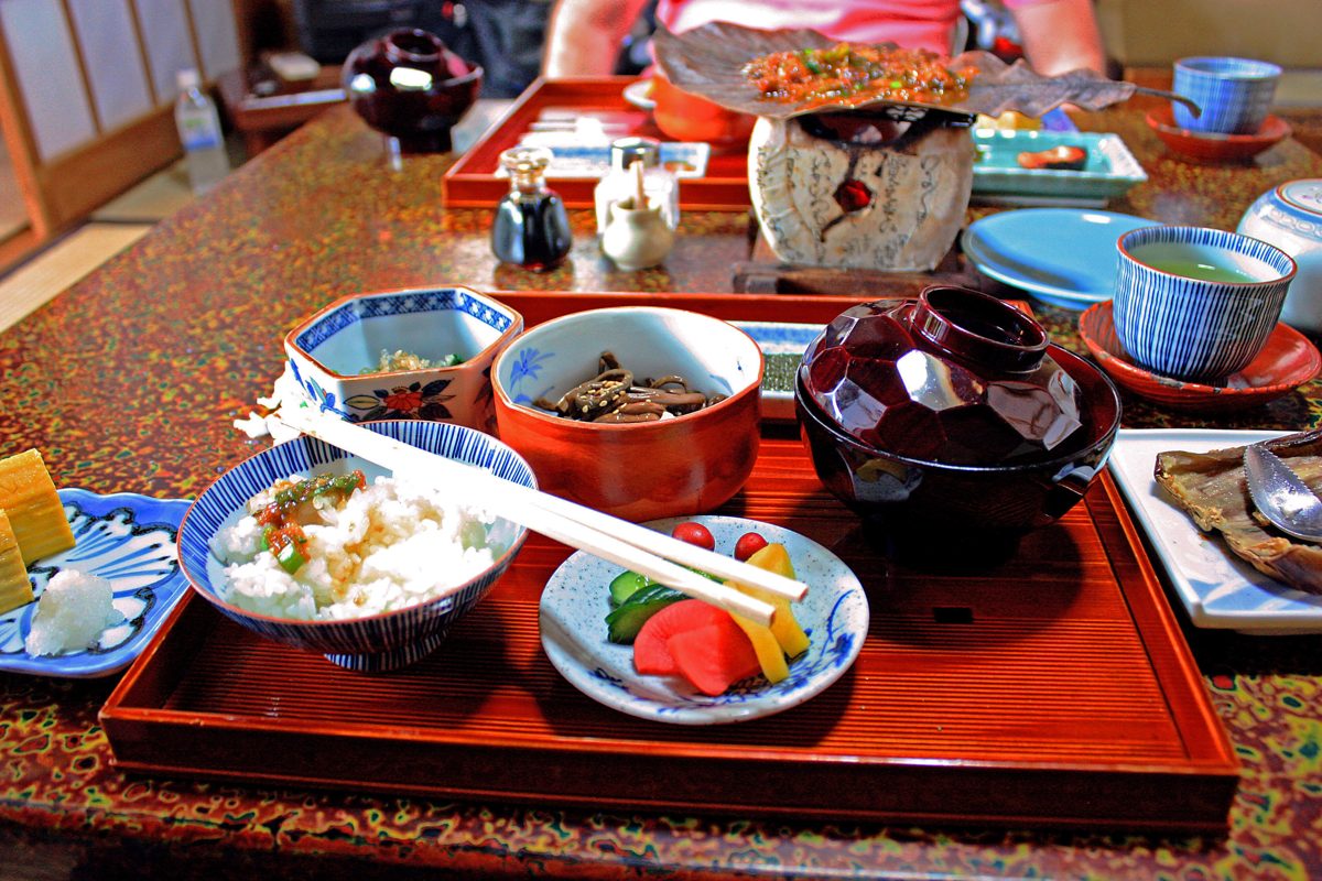 A Japanese breakfast on a red lacquer tray with rice, miso soup and pickles