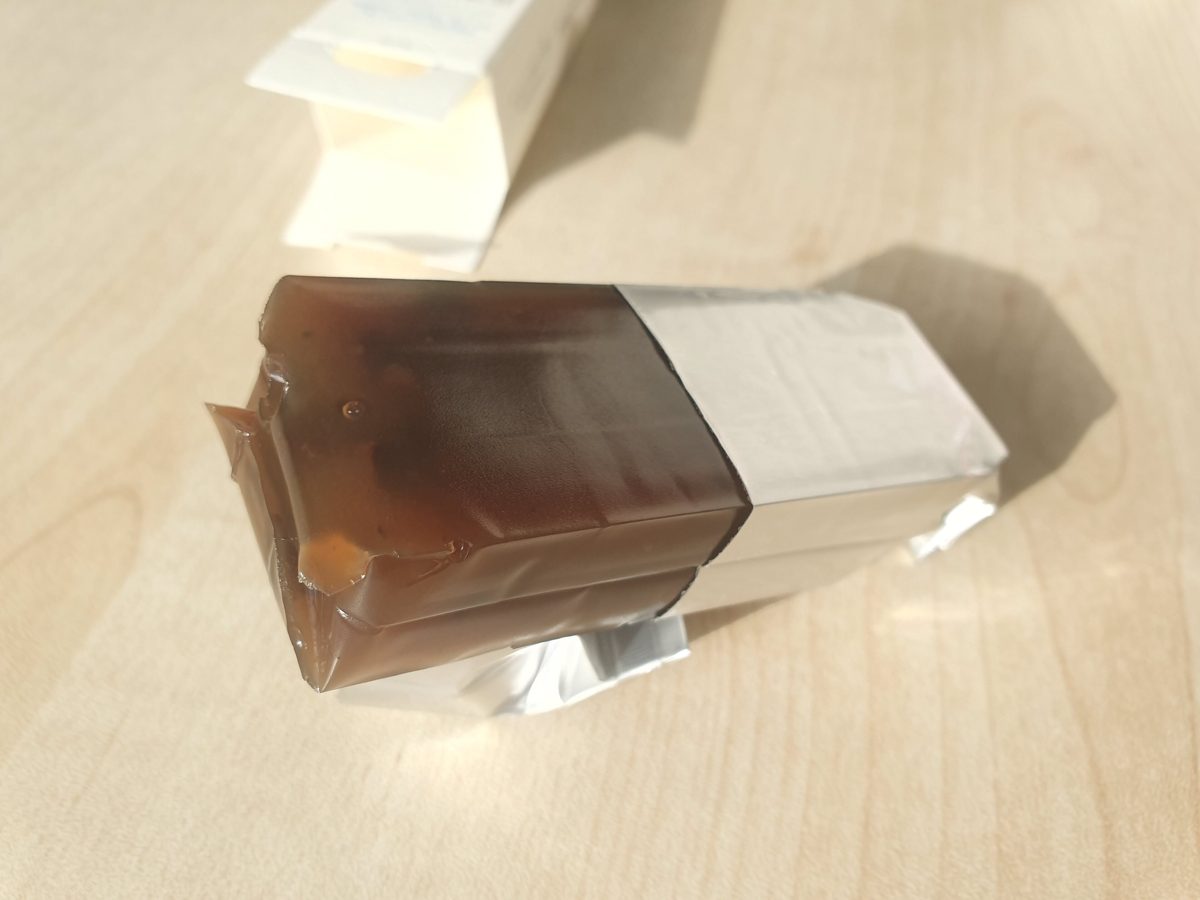 A stick of yokan being unwrapped from its foil sleeve