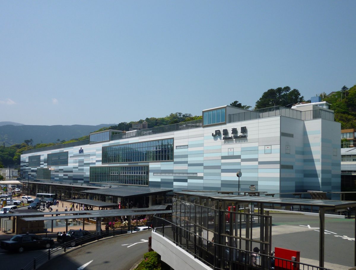 Modern station building of JR Atami Station seen from above, with the bus area in front