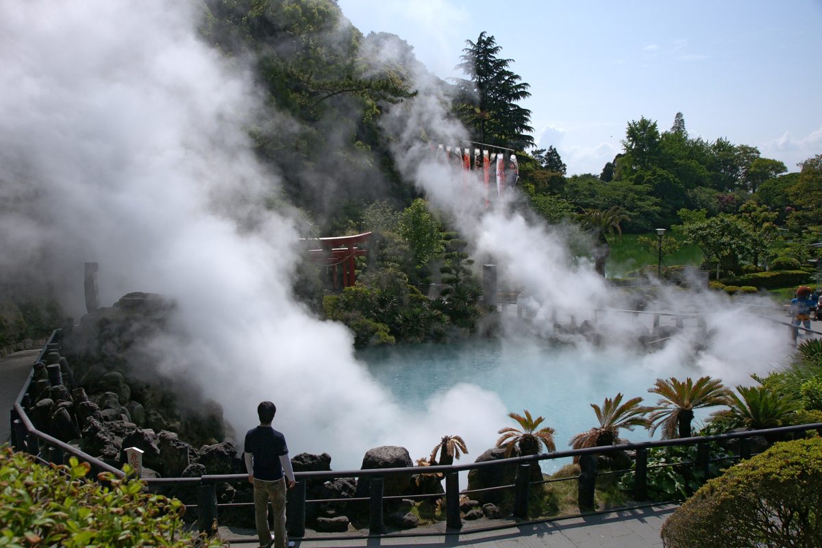 Steam rising from the blue pond at Umi Jigoku in Beppu on a sunny day