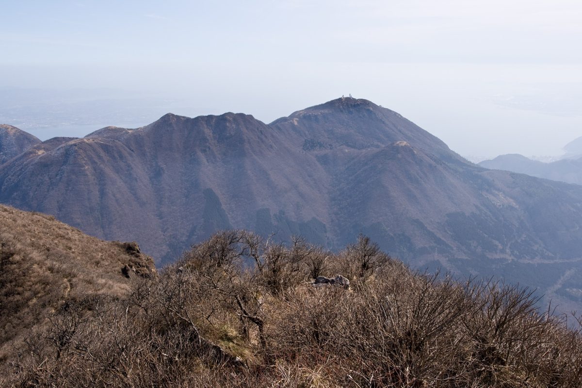 Mount Tsurumi, the mountain behind Beppu, seen across a ridge of bare winter shrubs
