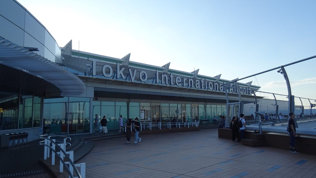An outdoor observation deck at Haneda Airport Terminal 3 with the terminal sign behind it
