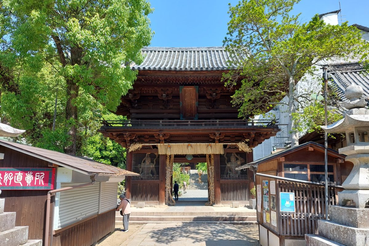 Wooden two-story Nio gate of Ishiteji temple framed by green trees