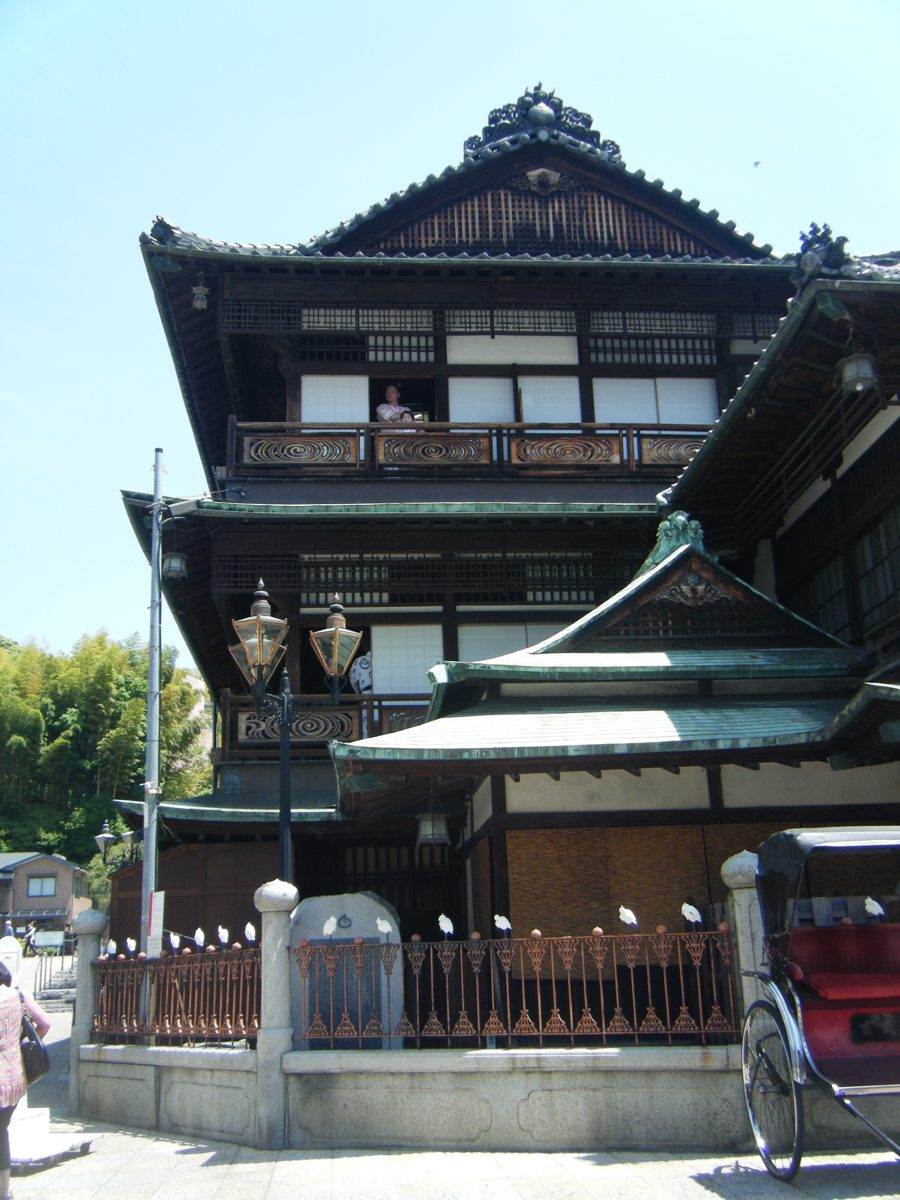 Side view of the tiered wooden roofs of Dogo Onsen Honkan