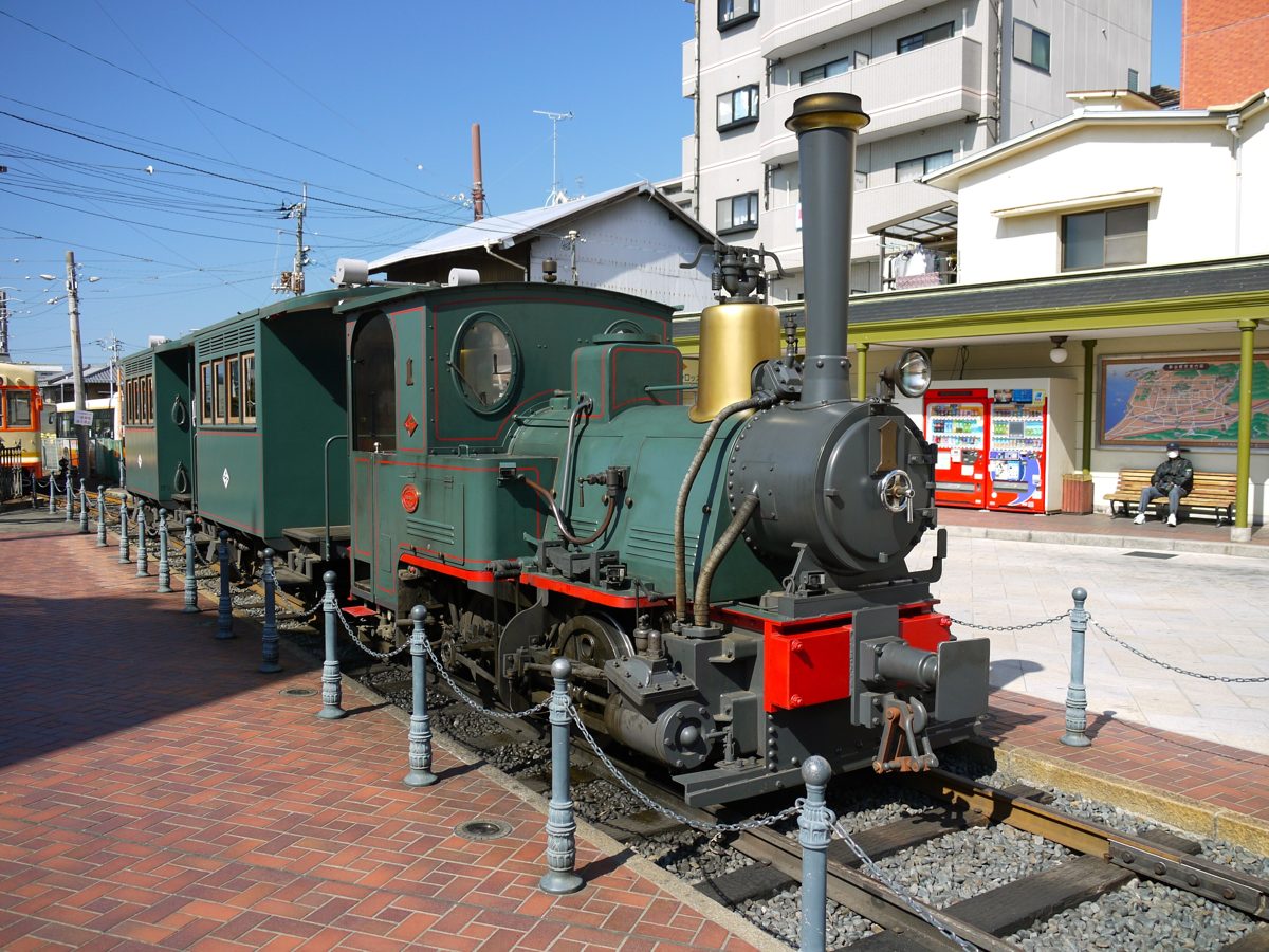 A green steam-style Botchan Train standing at Dogo Onsen Station