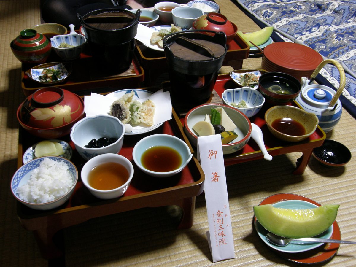 A spread of vegetarian temple dishes on red lacquer trays