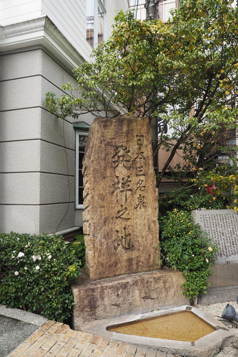 A carved stone monument beside a small basin in Gero Onsen