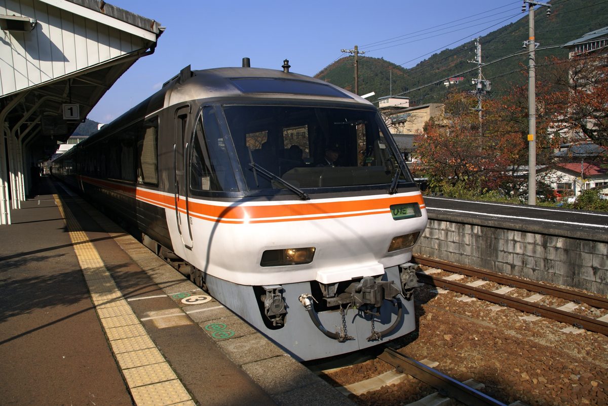 A silver and orange limited express train standing at a station platform