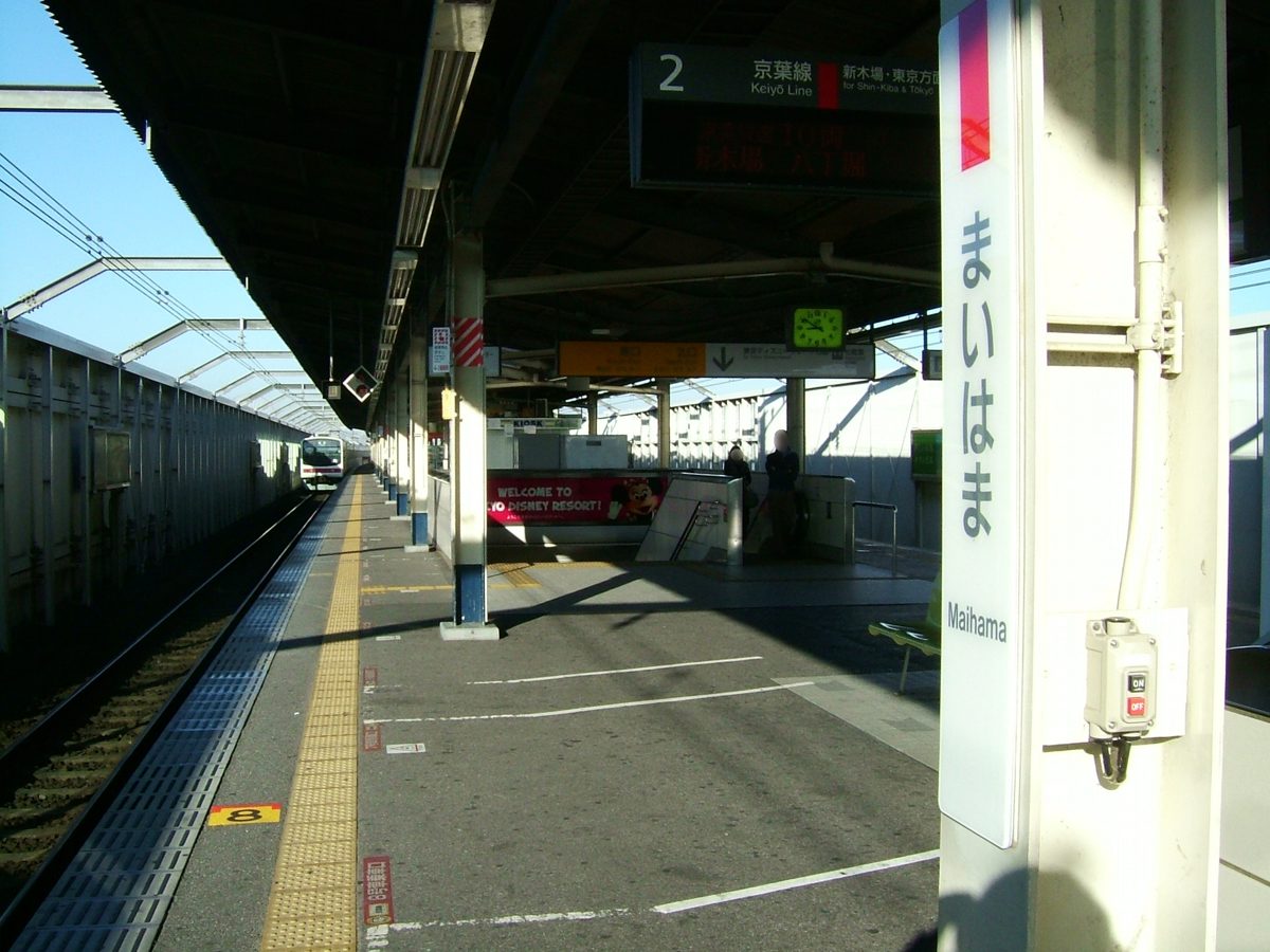 A long railway platform with a roof and signs
