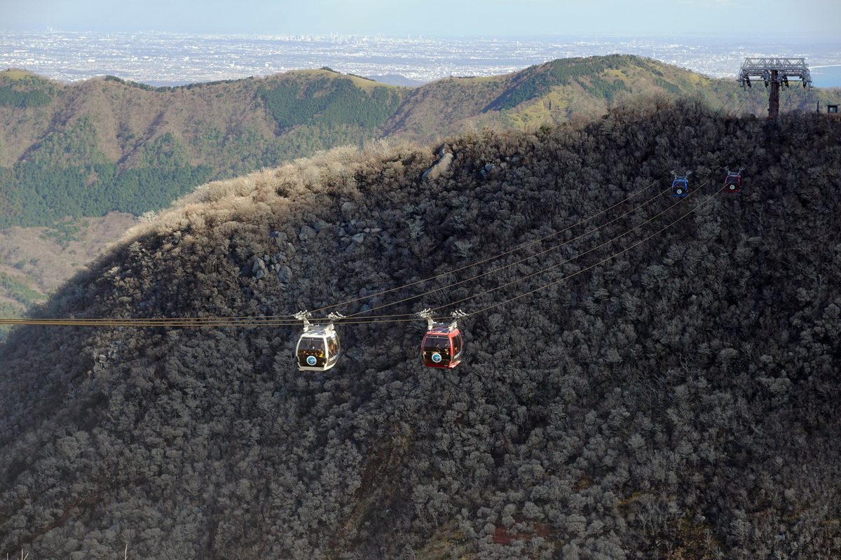 Ropeway gondolas passing over a brown mountainside at Owakudani