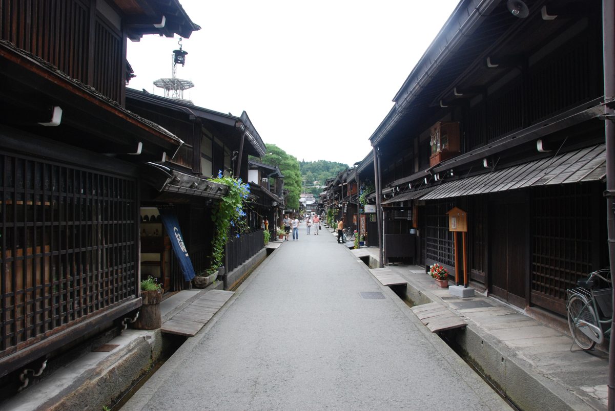 A quiet street of dark wooden merchant houses in the Sanmachi old town of Takayama