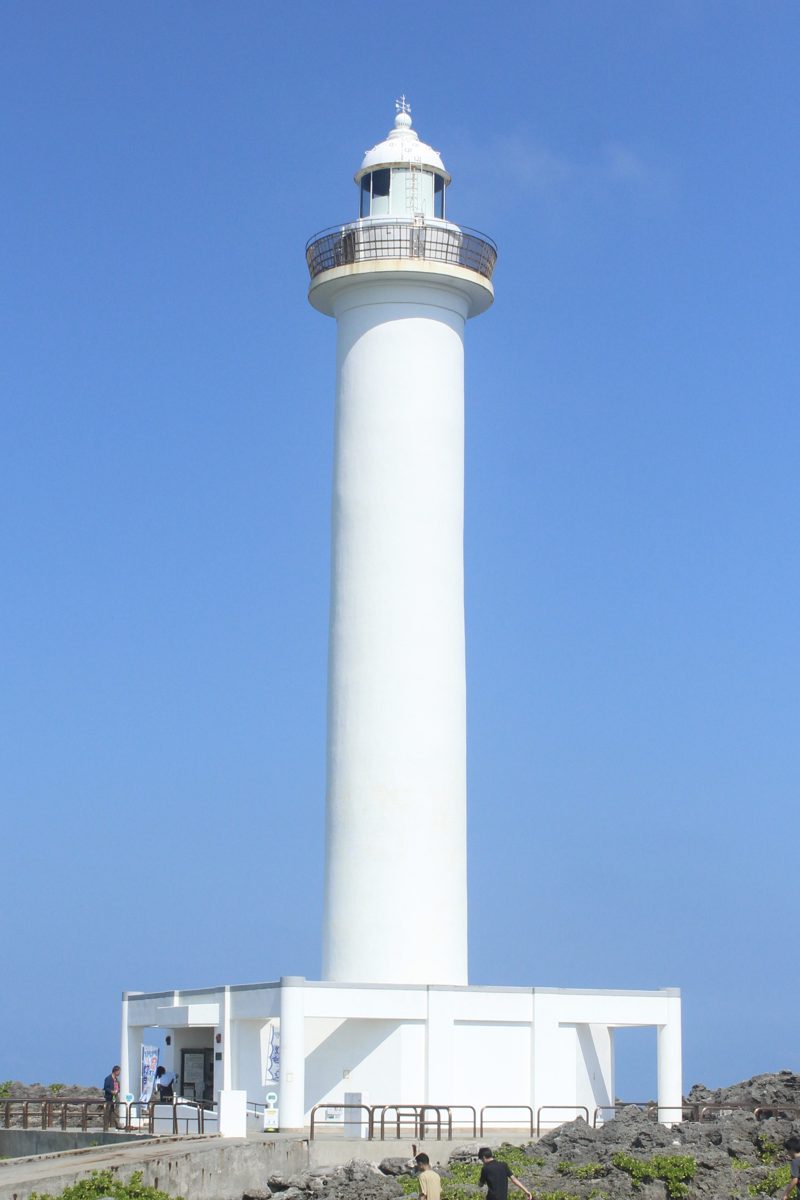 A white lighthouse against a clear blue sky