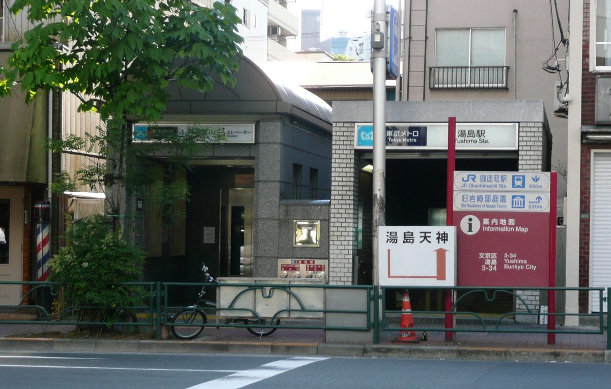 A Tokyo Metro entrance and elevator building for Yushima Station, with signs pointing to Yushima Tenjin and JR Okachimachi