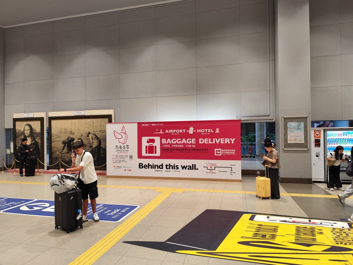 A railway station platform with travelers and suitcases