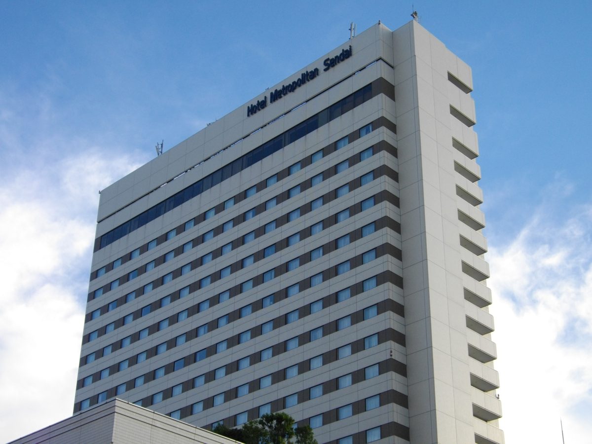 A tall white hotel tower with the name Hotel Metropolitan Sendai near the top