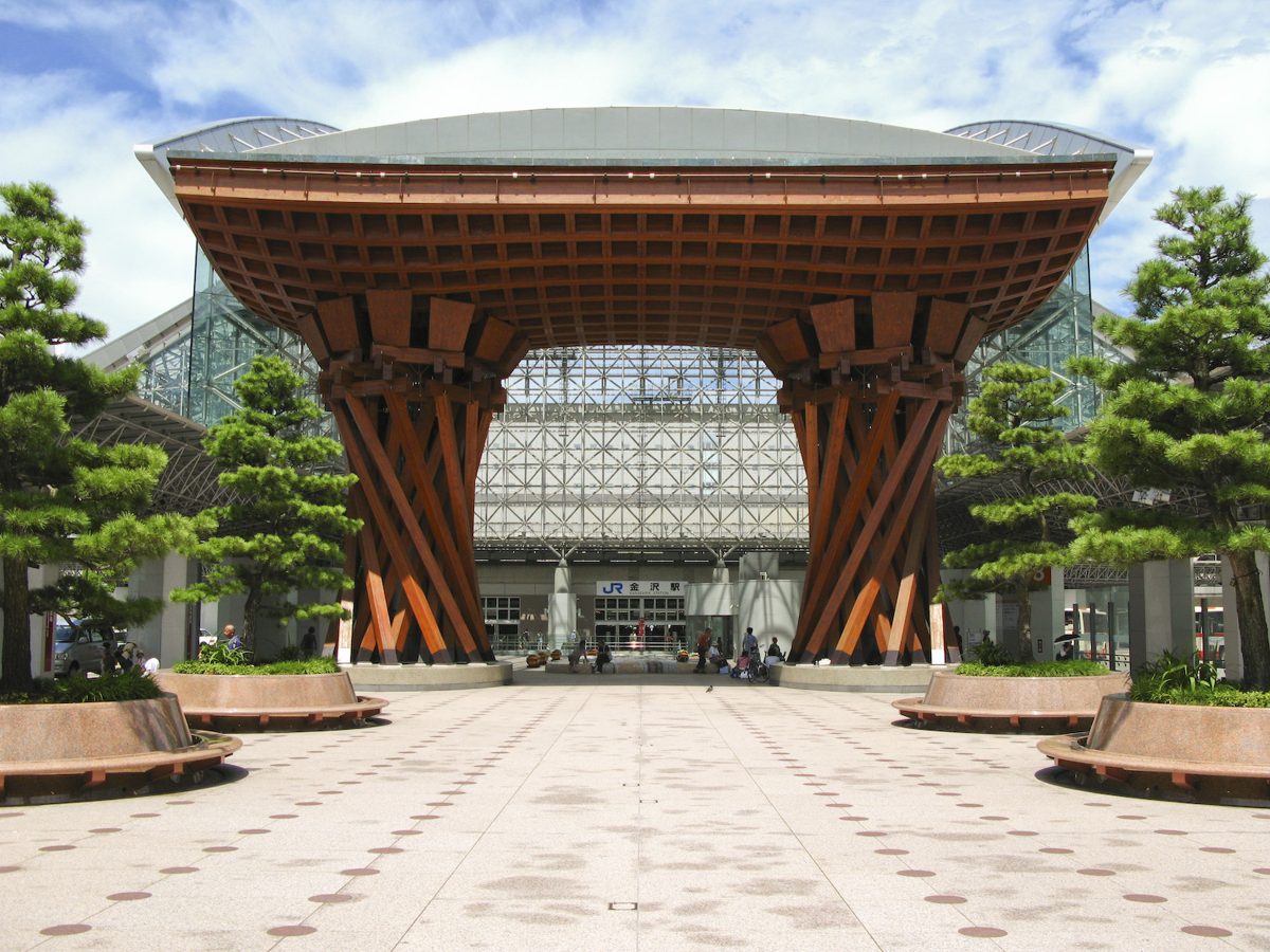 A huge wooden drum-shaped gate in front of a glass station dome