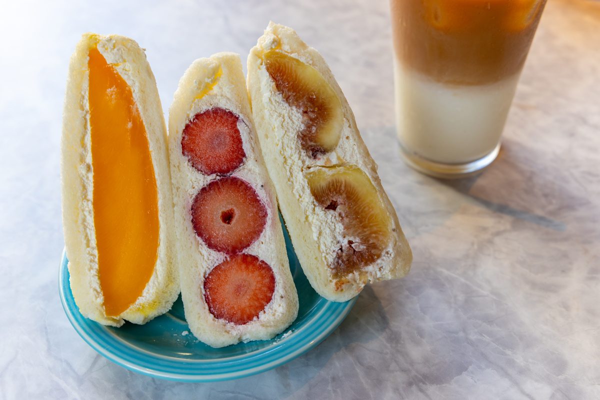 Three fruit sandwich halves with mango, strawberry and fig in cream