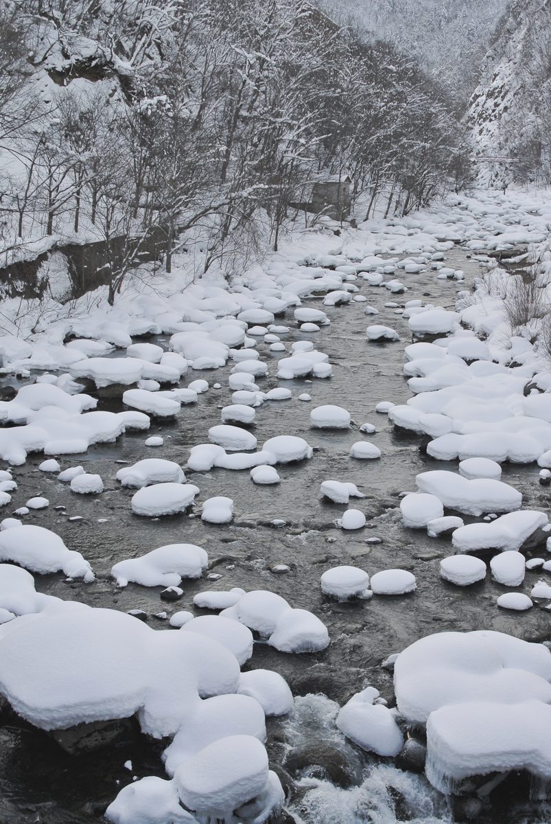 Snow-covered rocks in a river in winter