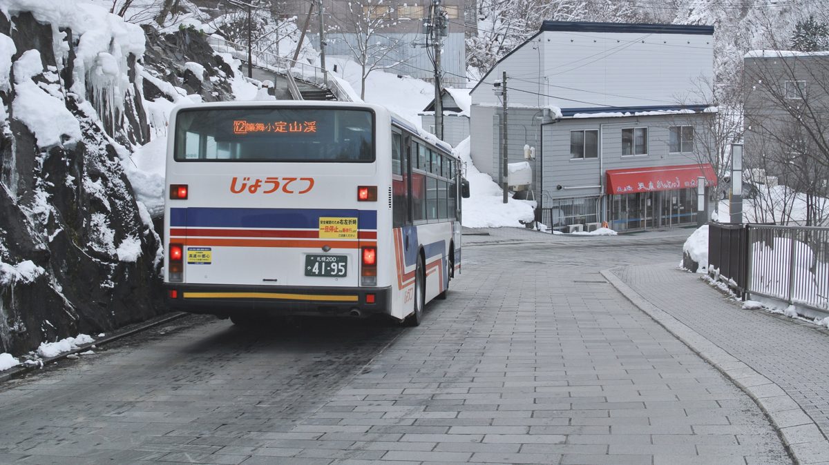 A Jotetsu bus driving along a snowy street in Jozankei Onsen
