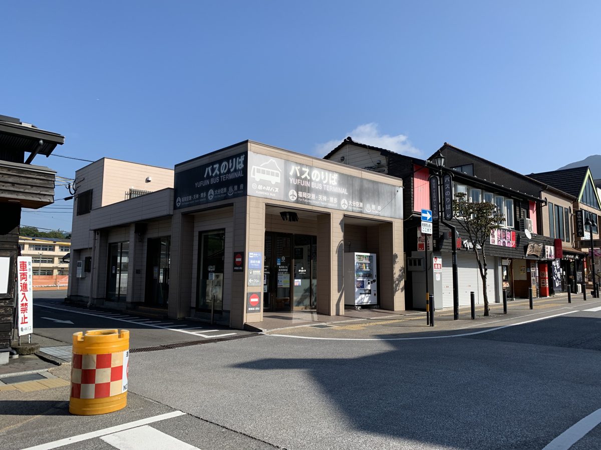 A small bus terminal building on a sunny street corner