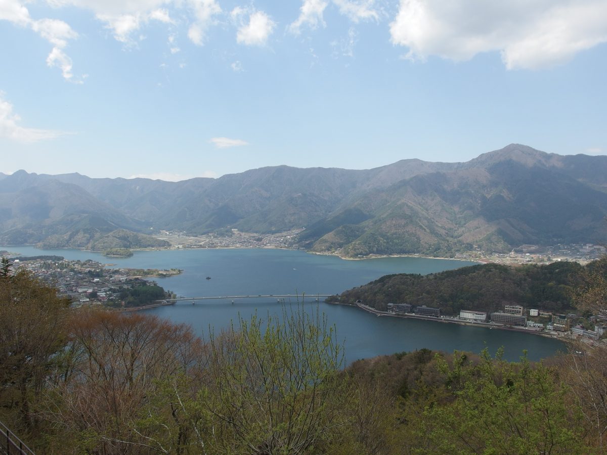 Lake Kawaguchi and the surrounding mountains seen from a hillside on a clear spring day