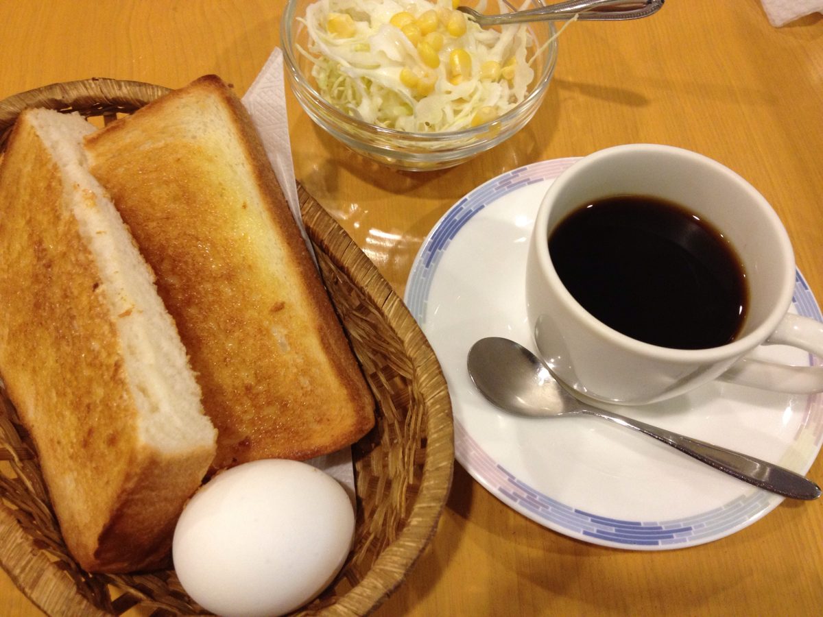 A kissaten breakfast of thick toast, a boiled egg, shredded cabbage and black coffee