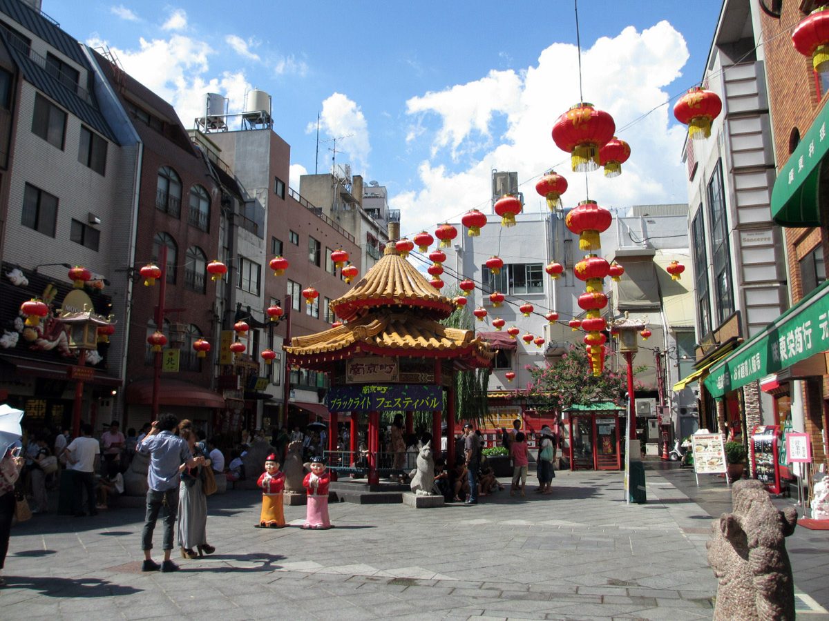 A square lined with red lanterns and a Chinese-style pavilion under a sunny sky