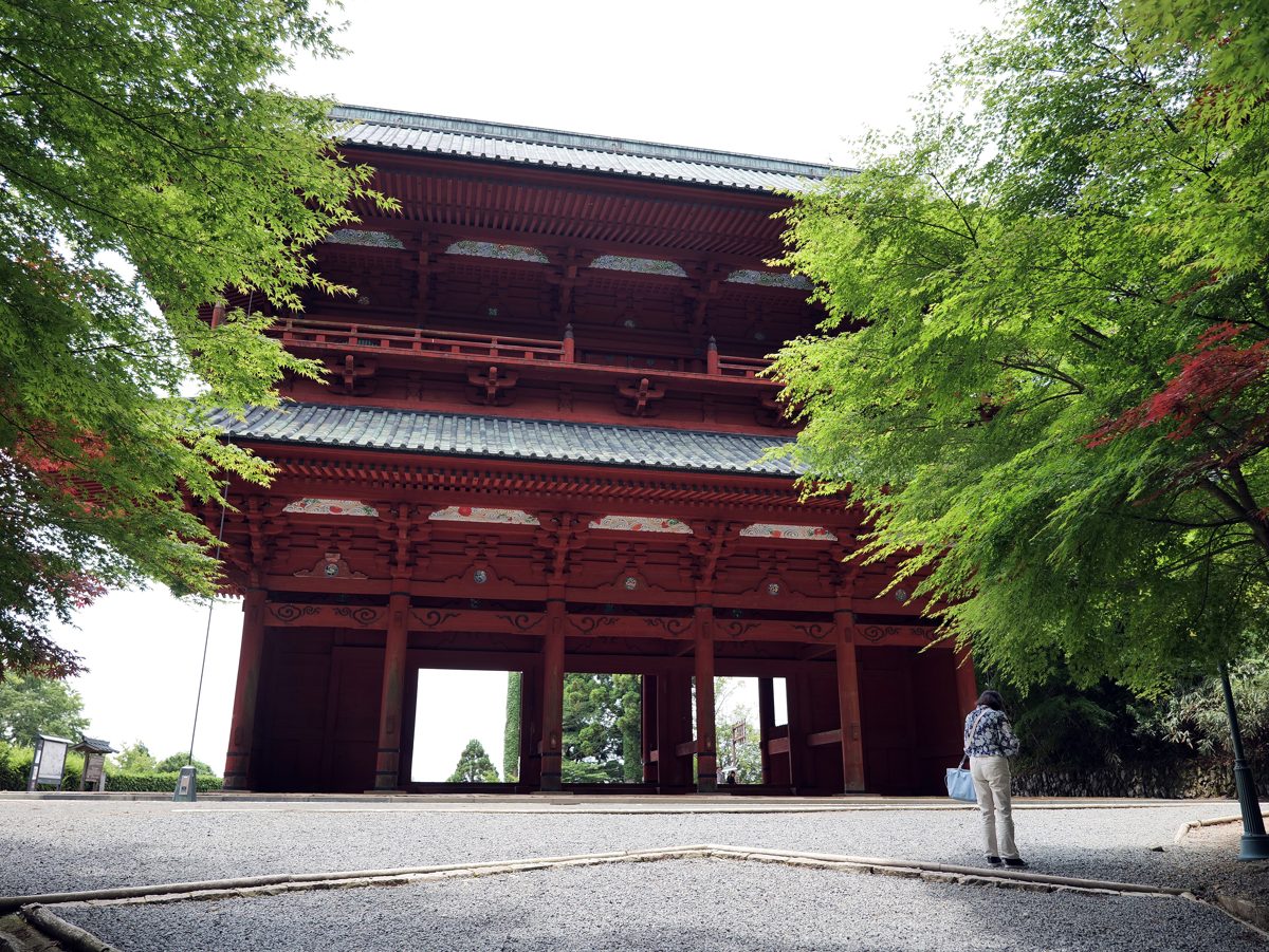 The large red Daimon gate of Koyasan between green trees