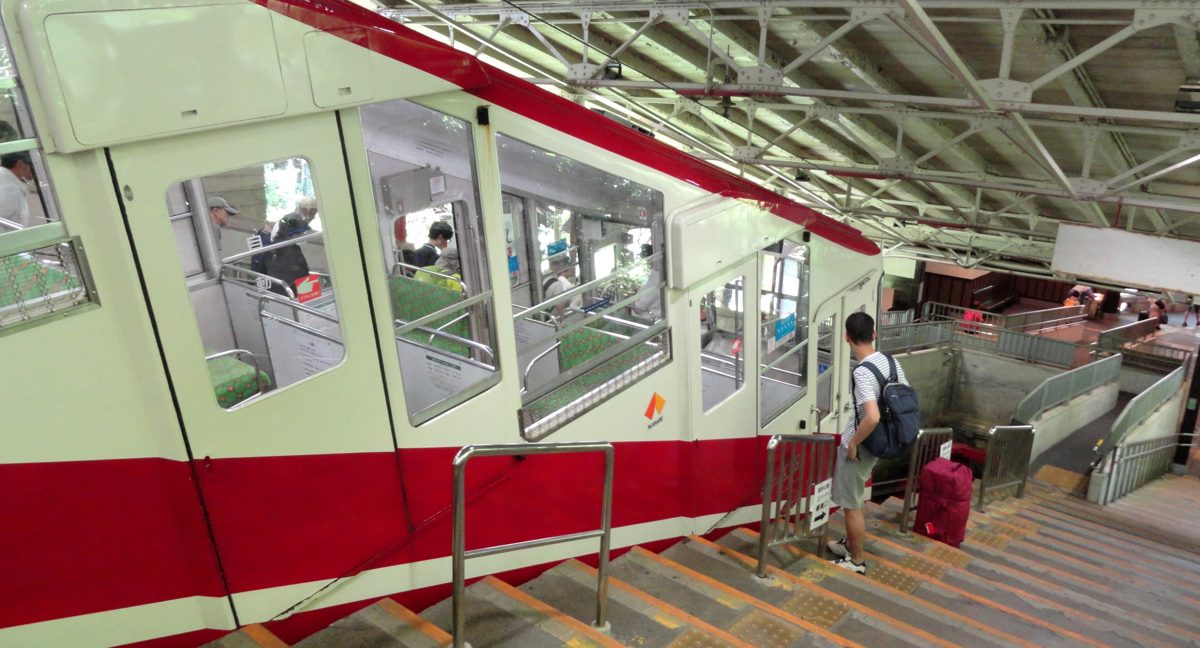 A red and white cable car at Gokurakubashi station