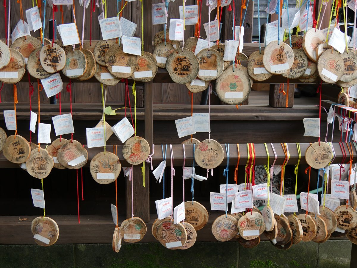 Many round wooden bathing tokens with paper tags hanging on strings