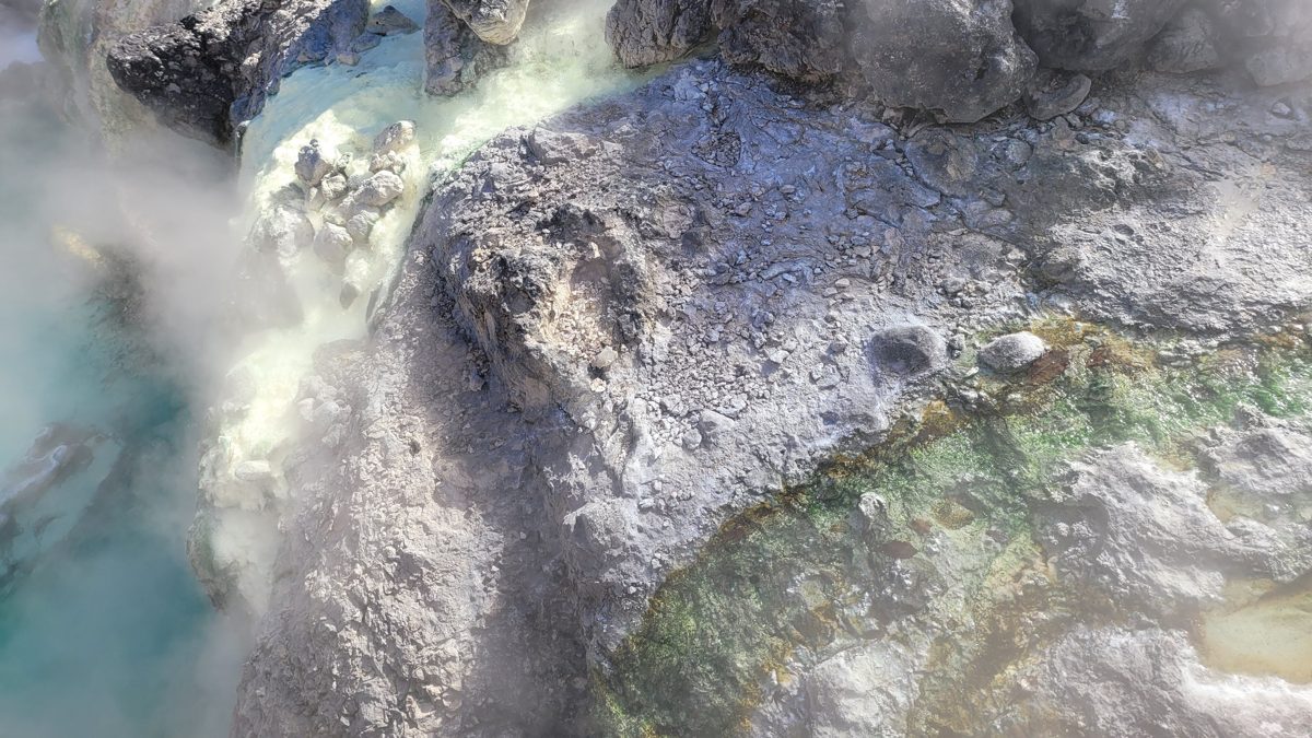 Close-up of steaming hot-spring water and mineral-coated rocks at Yubatake in Kusatsu