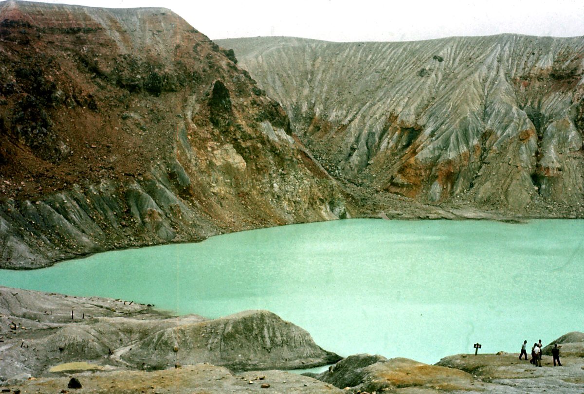 Turquoise crater lake surrounded by bare gray volcanic slopes on Mount Shirane