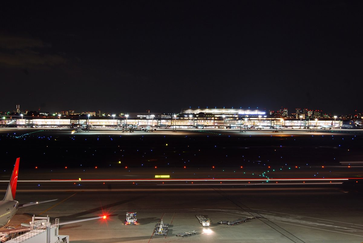Haneda Airport International Terminal lit up at night across the runways