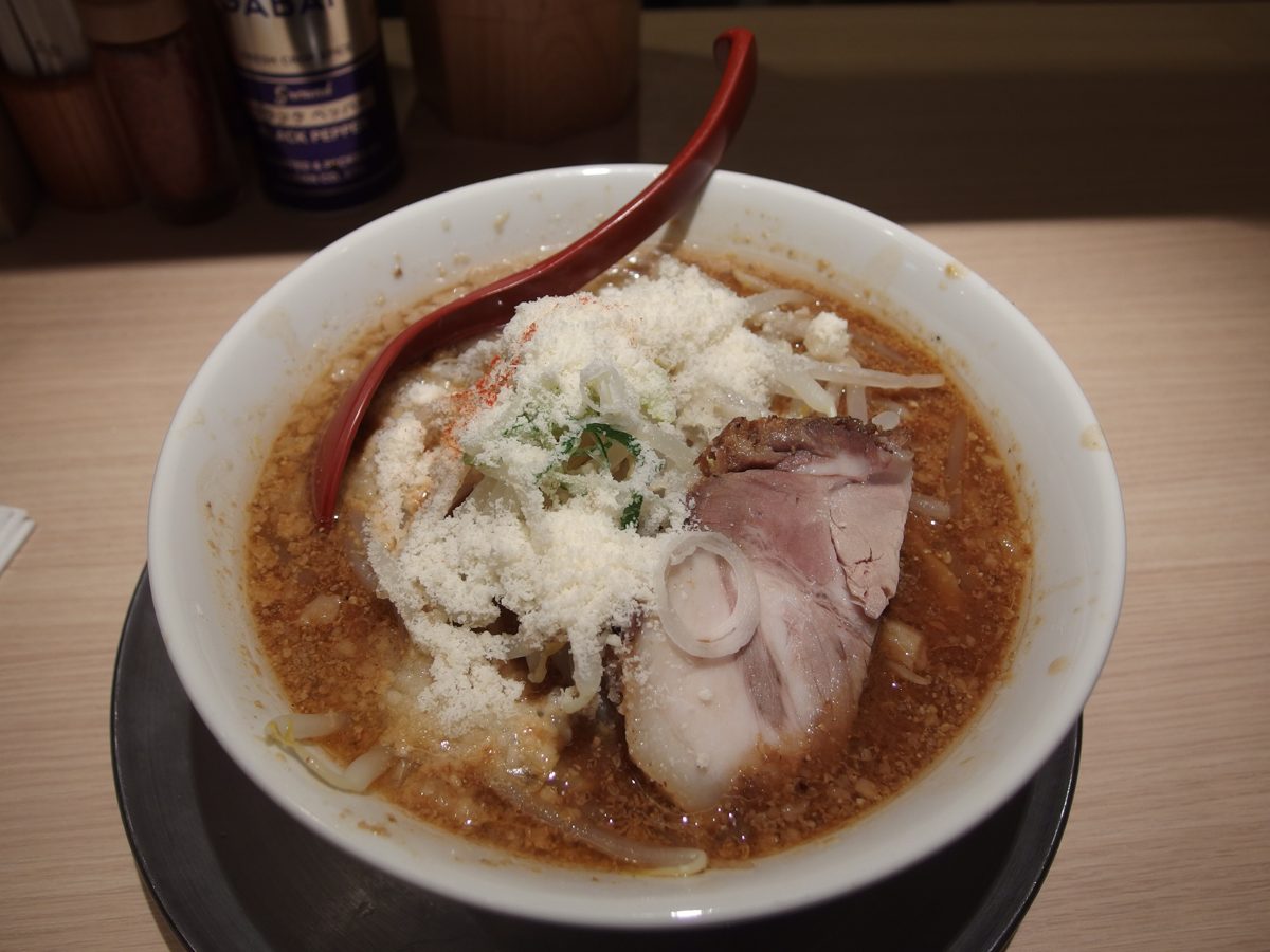A bowl of miso ramen topped with grated cheese and chashu pork