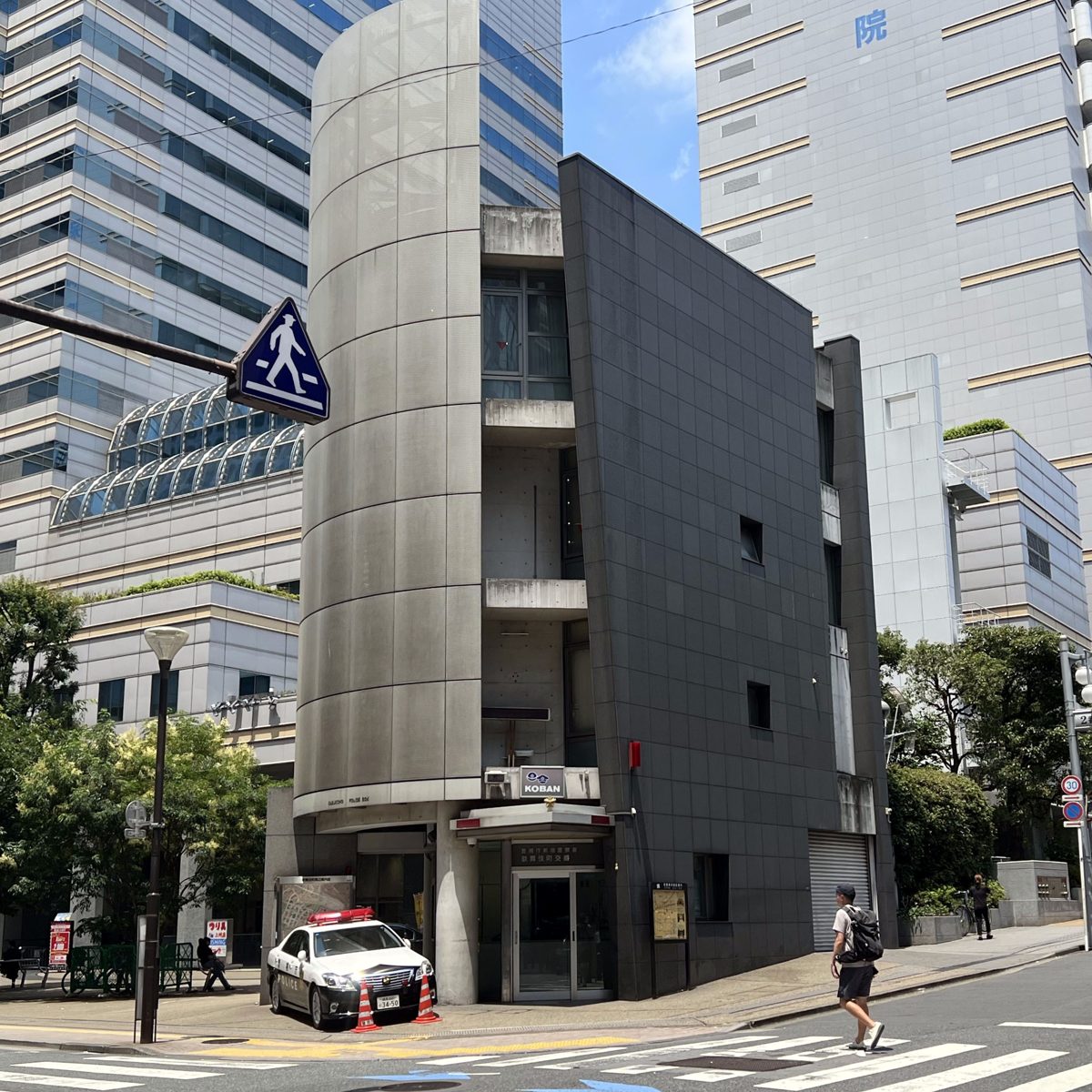 A tall, narrow koban building with a police car parked outside in Kabukicho, Tokyo