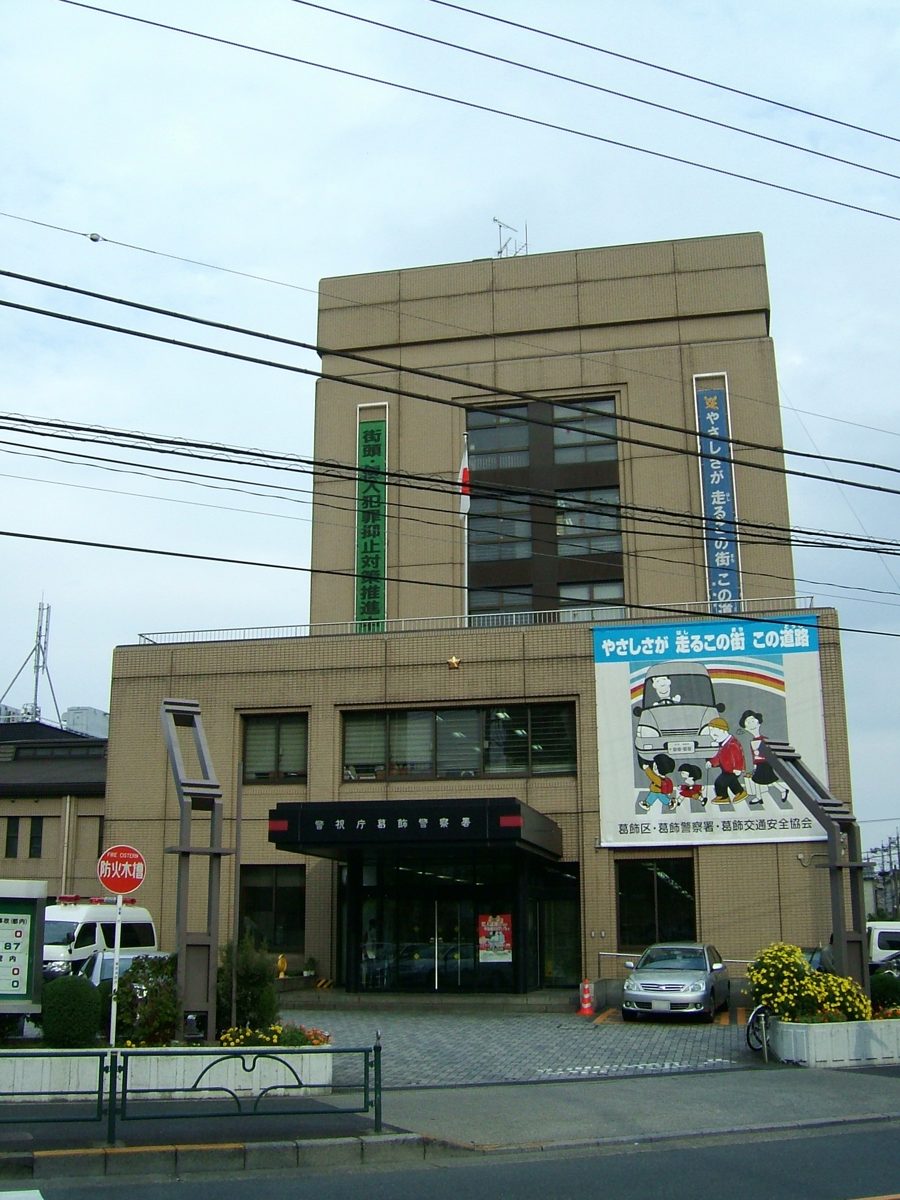 The exterior of Katsushika Police Station, a multi-story building in Tokyo