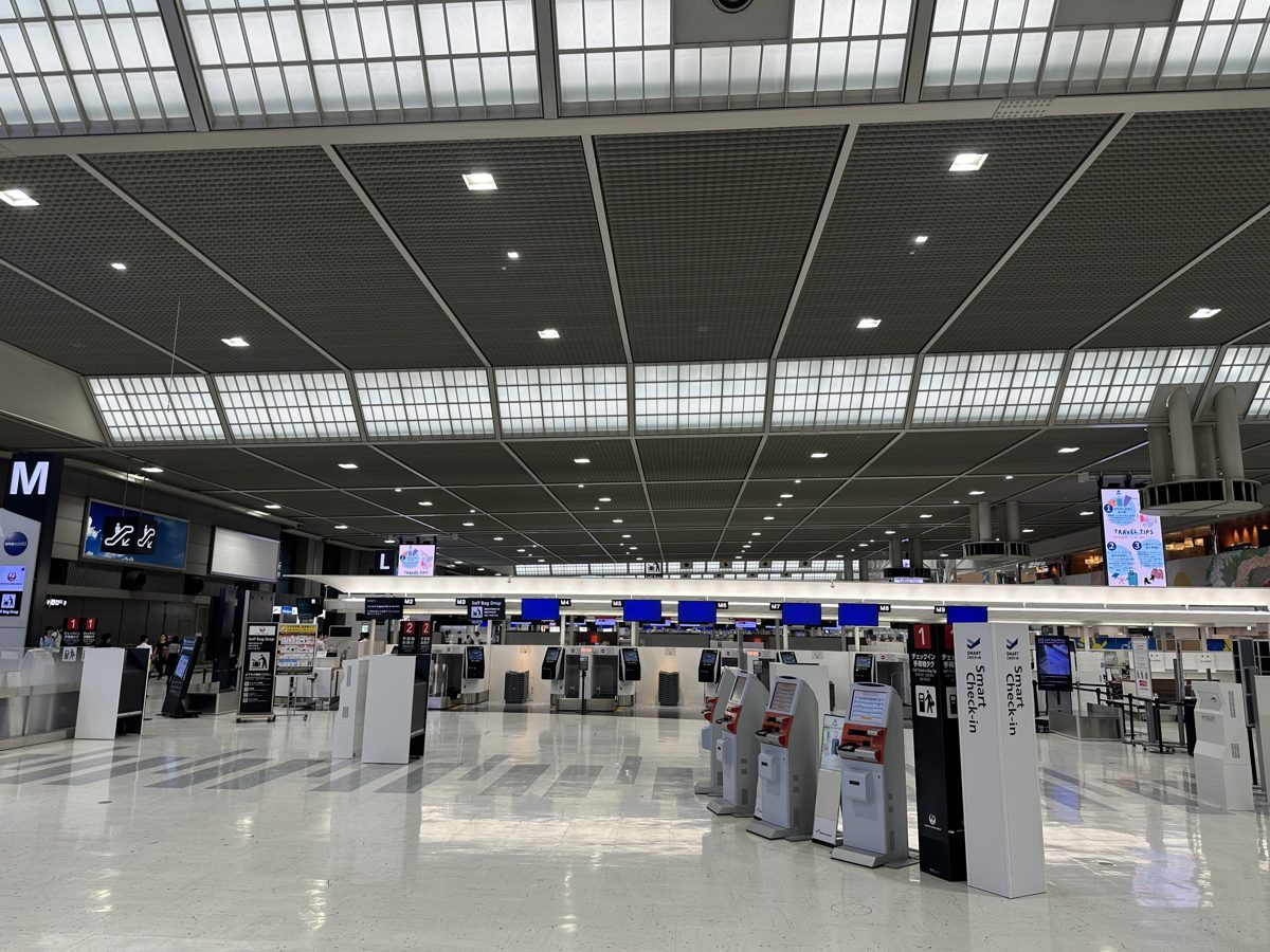 A wide, bright check-in hall with self-service kiosks at Narita Airport Terminal 2