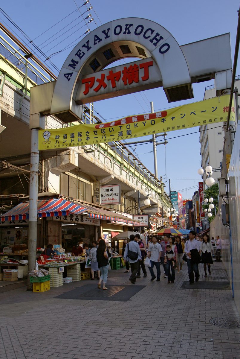 A busy shopping street under an arched entrance sign
