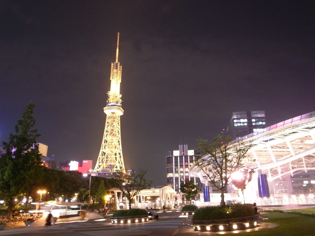 Nagoya TV Tower lit up at night next to the illuminated roof of Oasis 21