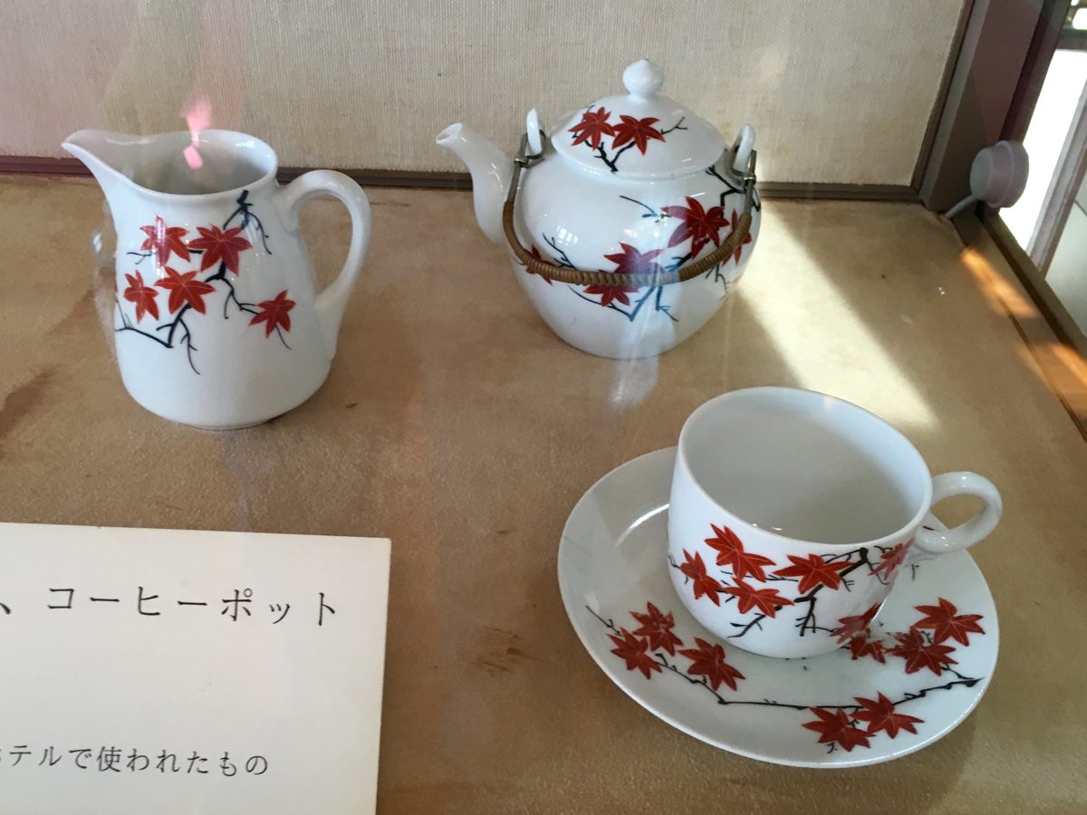 A white coffee pot, milk jug and cup painted with red maple leaves