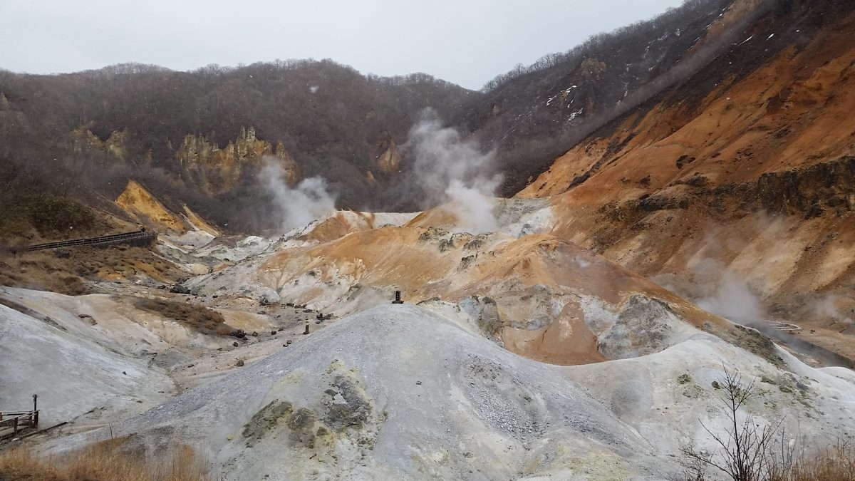 Steam rising from pale volcanic ground in Jigokudani, Noboribetsu Onsen