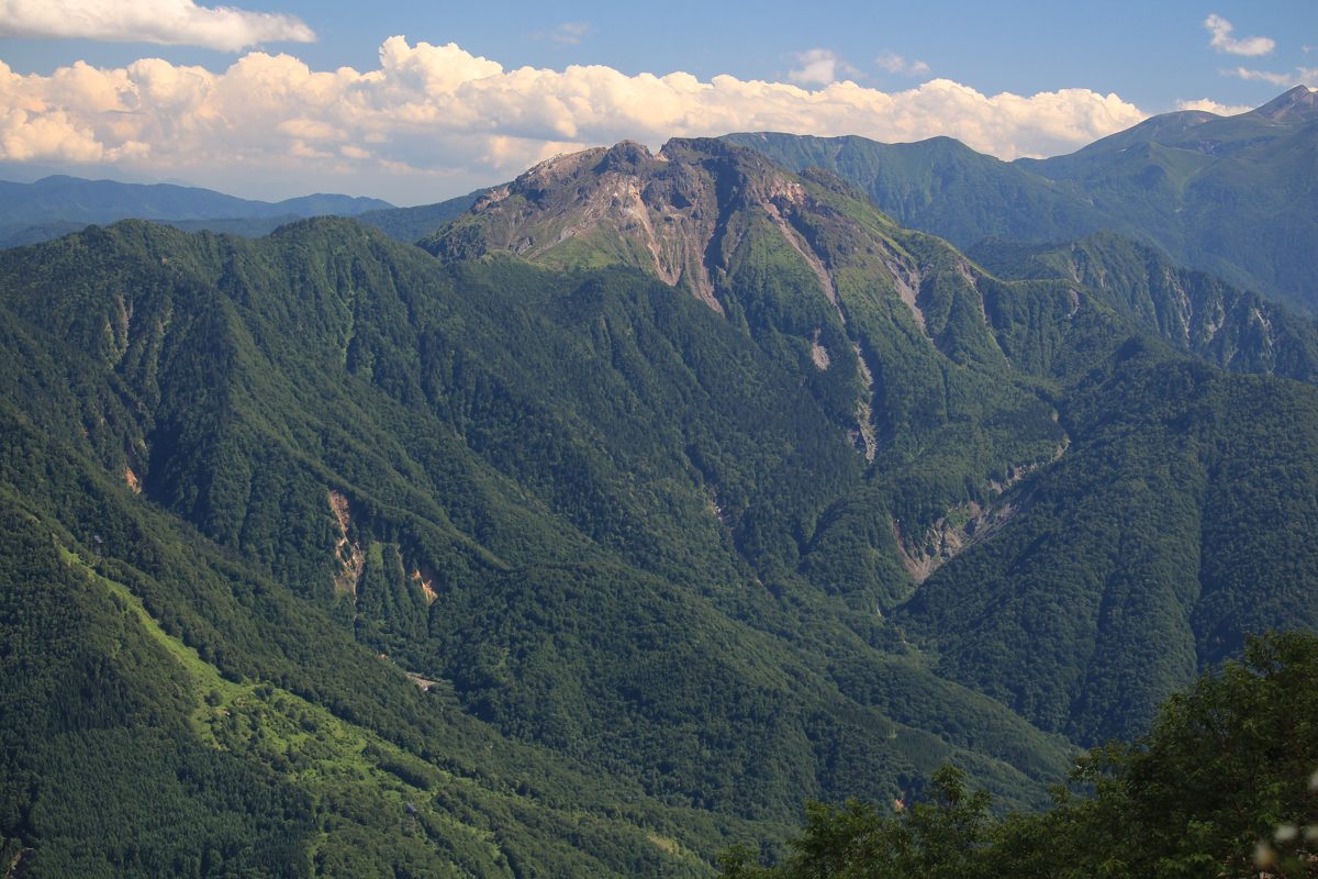 Mount Yake rising above forested green valleys under white clouds