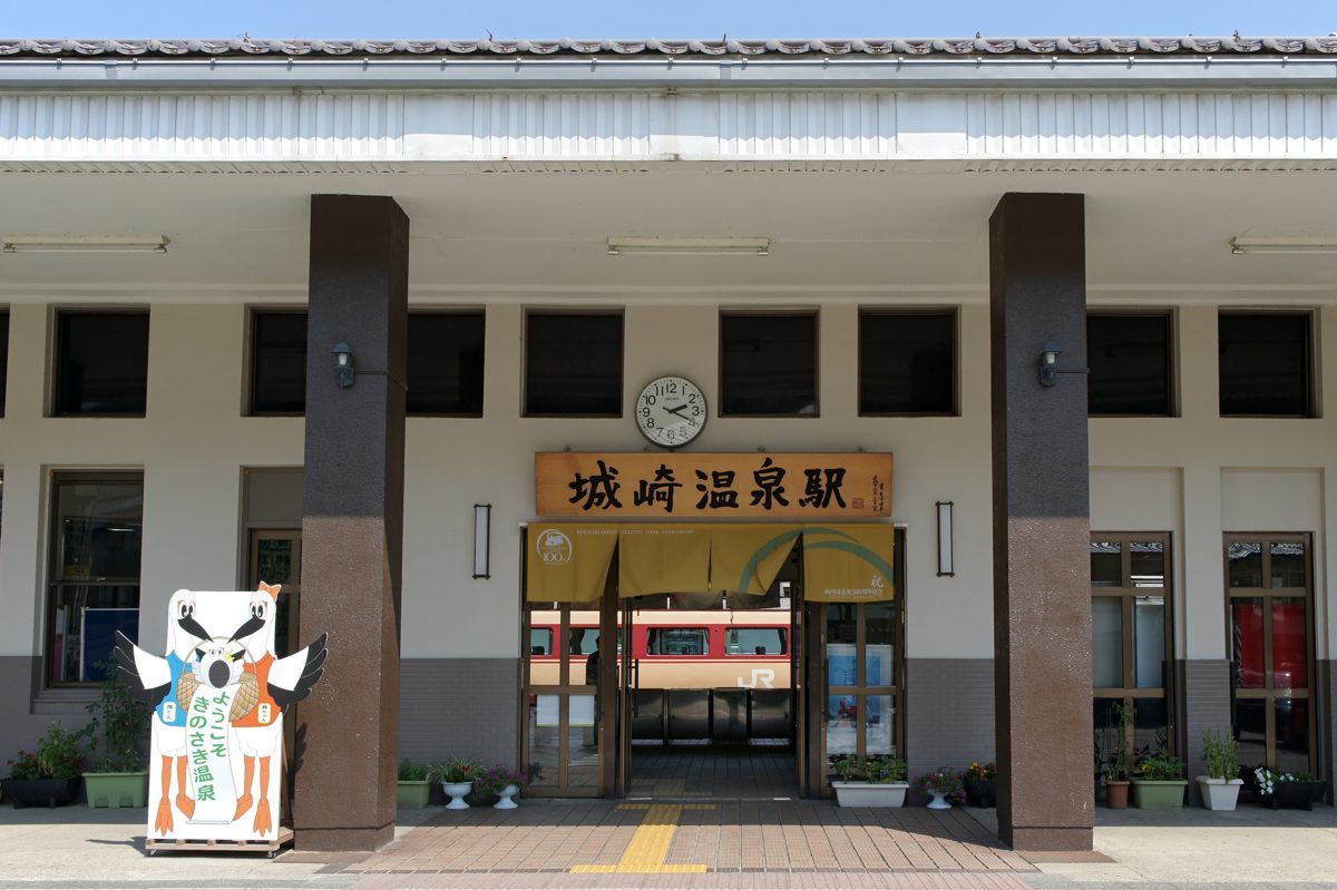 A small railway station building with a clock above the entrance