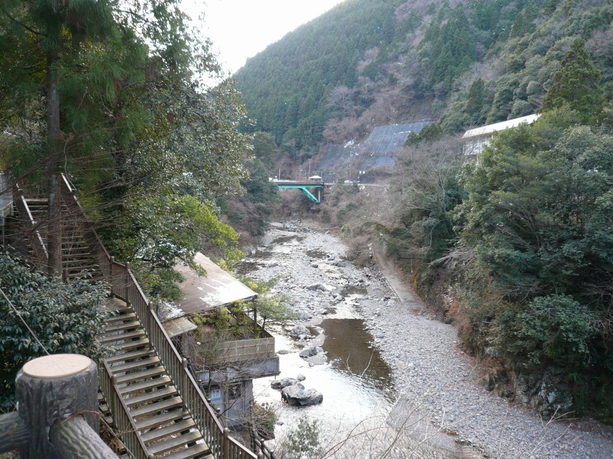 A rocky river valley with wooden stairs and wooded mountains in daylight