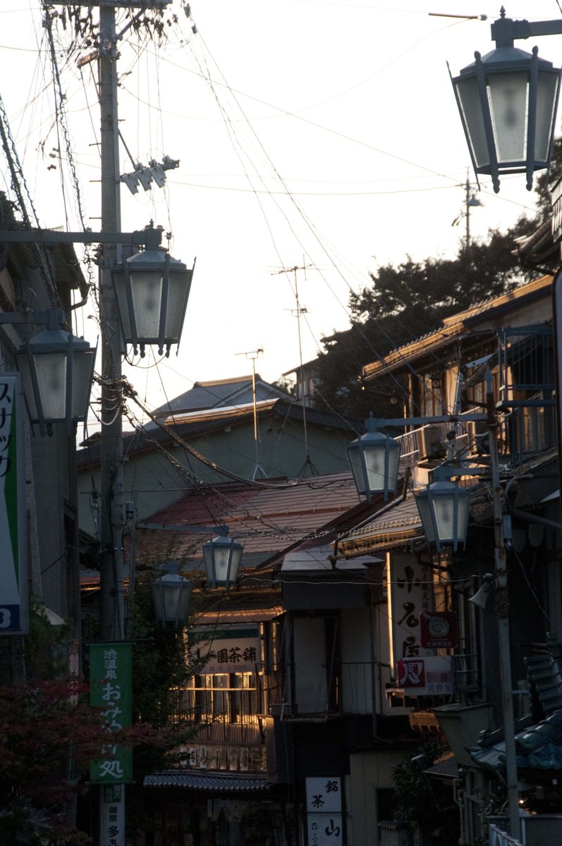 Old wooden buildings and street lamps along a lane in Shibu Onsen
