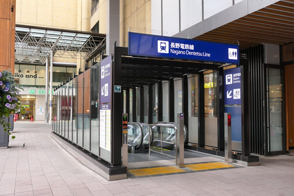 Escalator entrance with a blue Nagano Dentetsu Line sign