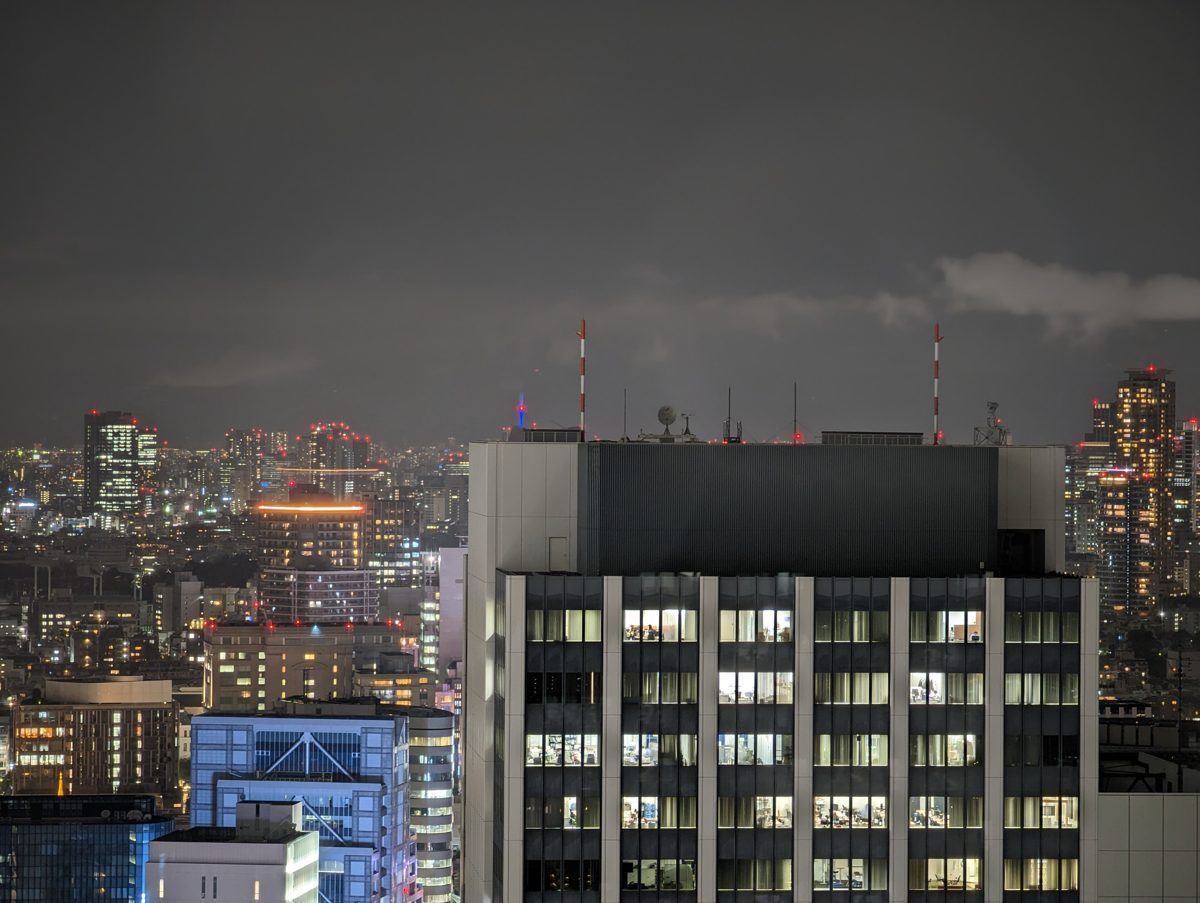 Office buildings with lit windows at night under a cloudy sky
