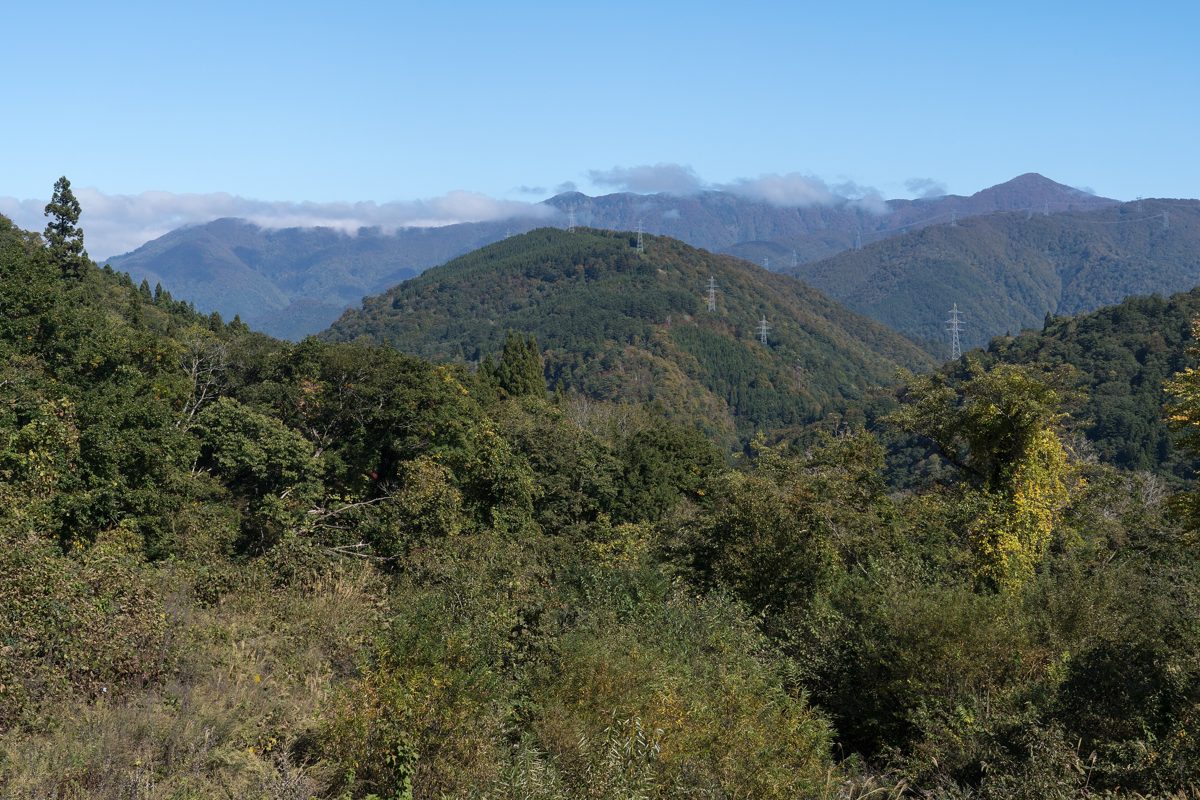 Forested mountains in Shirakawa village under a clear blue sky in autumn
