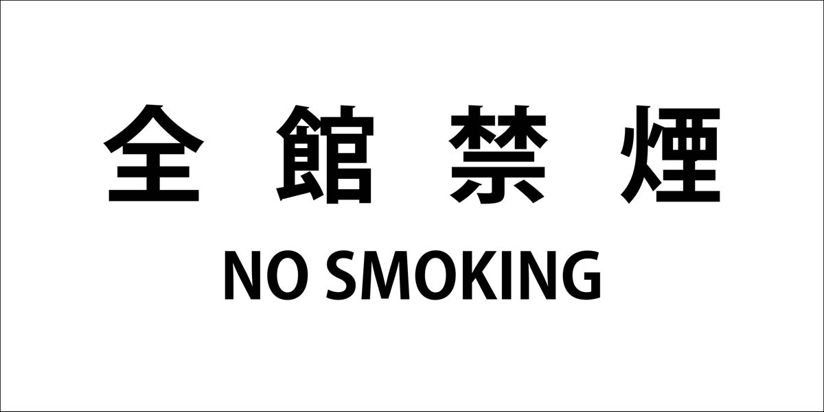 A white sign reading “whole building non-smoking” in Japanese with NO SMOKING underneath