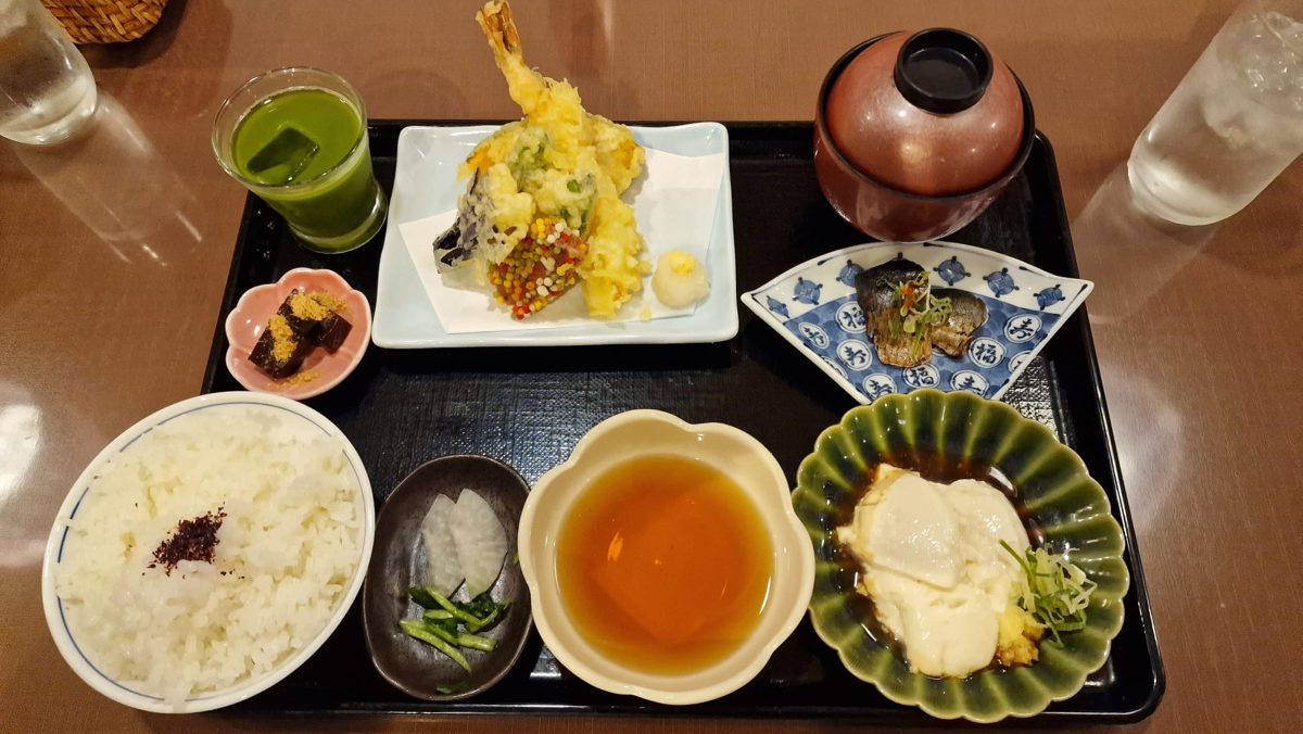 A Japanese set meal on a tray with rice, tempura, simmered fish, tofu and soup